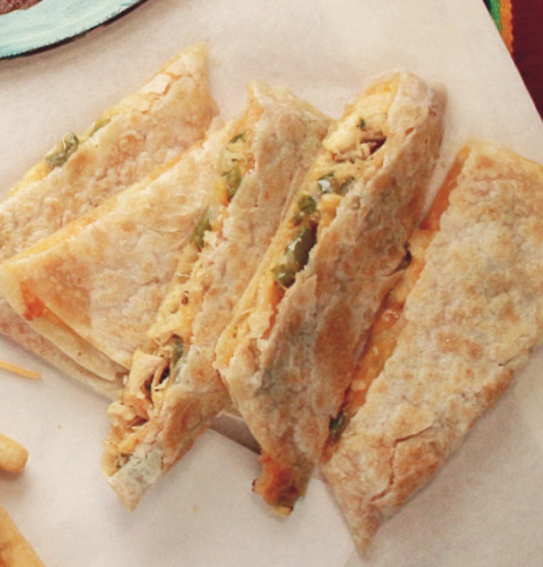 Chicken Machaca Quesadilla wedges with melted cheese and jalapeños